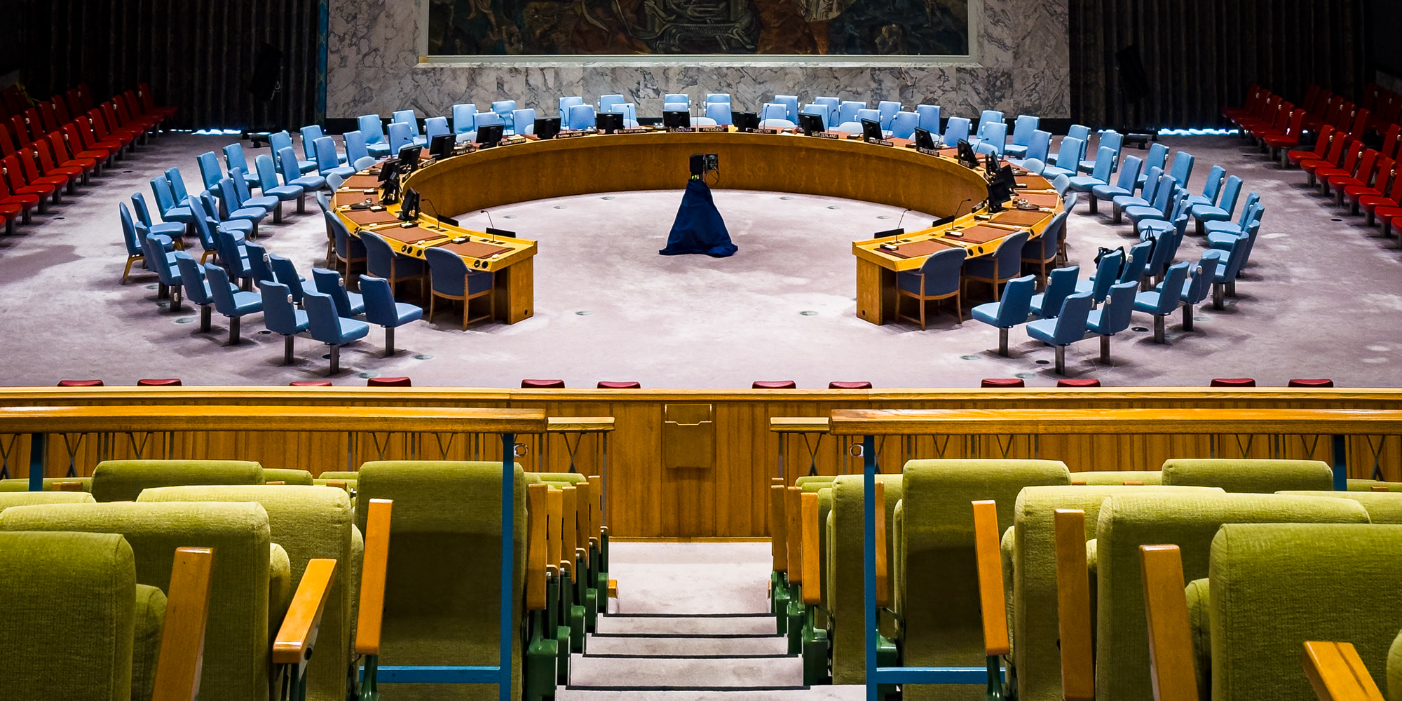 Delegates seated around the United Nations Security Council horseshoe table, with the chamber mural behind the presidency